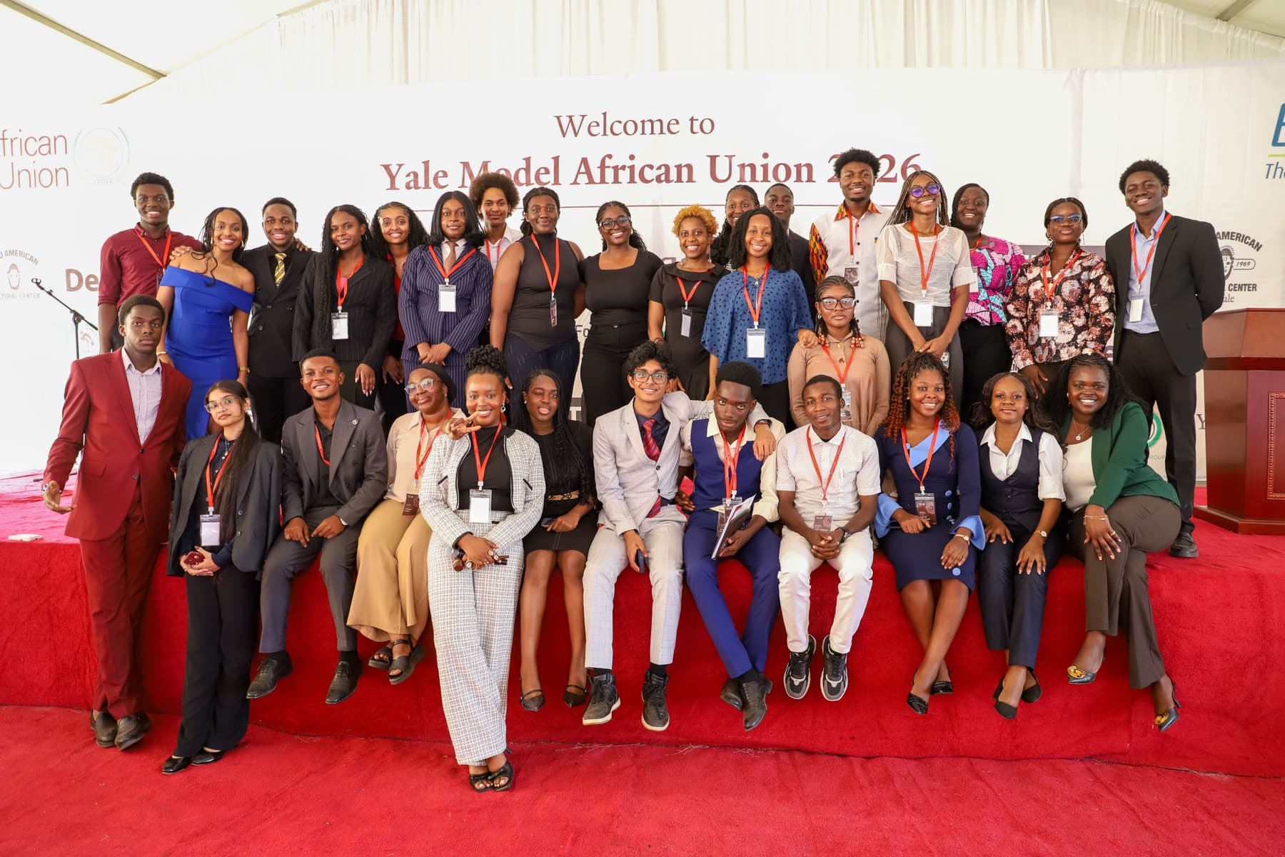 A large group of delegates and staff standing together on a red carpet beneath a Yale Model African Union banner.